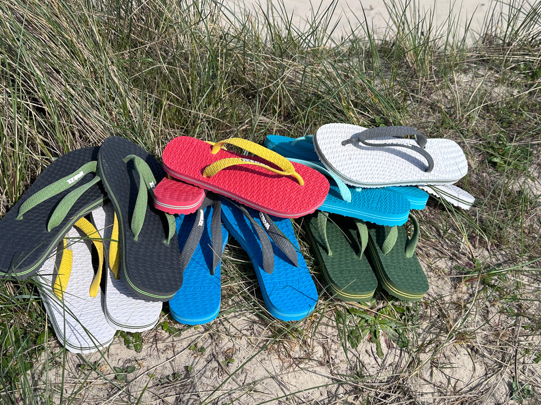 Several pairs of brightly coloured, non plastic, biodegradable Worzl flip flops